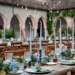 long rectangular wedding tables with light blue tall candles and neutral foliage at Italian wedding venue convento dell'Annunciata