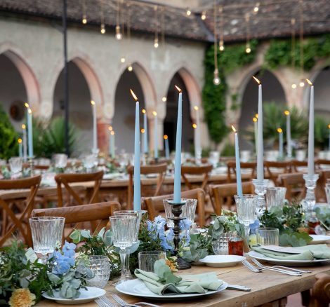 long rectangular wedding tables with light blue tall candles and neutral foliage at Italian wedding venue convento dell'Annunciata