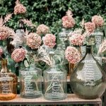 table names written in white ink on different glass vases at Italian wedding venue
