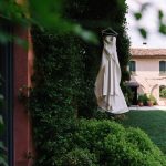 white strapless wedding dress hung outside with Italian wedding venue convent dell'Annunciata in the background