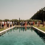 wedding guests surrounding outdoor pool area