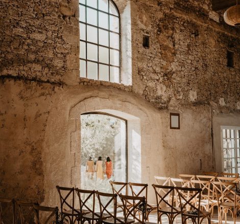 wooden ceremony chairs set up in rows inside the renovated barn at wedding venue in south of France le petit roulet