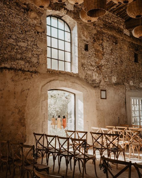 wooden ceremony chairs set up in rows inside the renovated barn at wedding venue in south of France le petit roulet