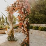 floral arch with dried flowers in pinks and creams at wedding venue in Cyprus liopetro