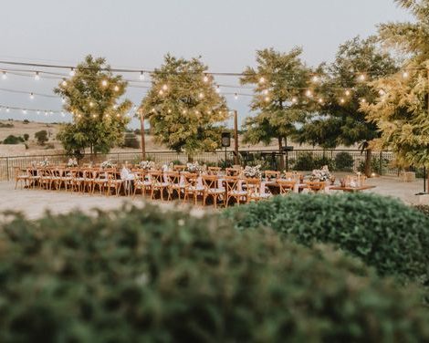 long wooden tables under fairy lights at wedding venue in Cyprus liopetro