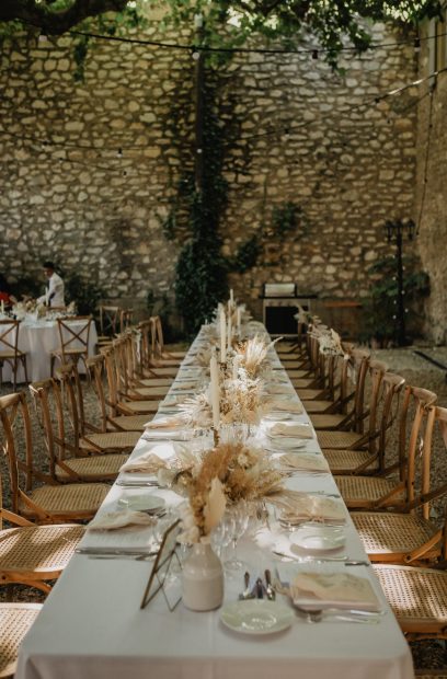 view up along wedding tables set up with neutral boho florals at le Petit Roulet wedding venue in luberon in france