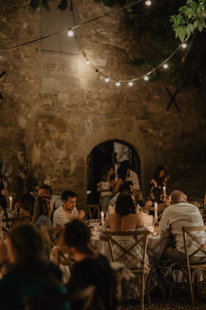 wedding guests celebrating whilst dining outside at le Petit Roulet wedding venue in luberon in france