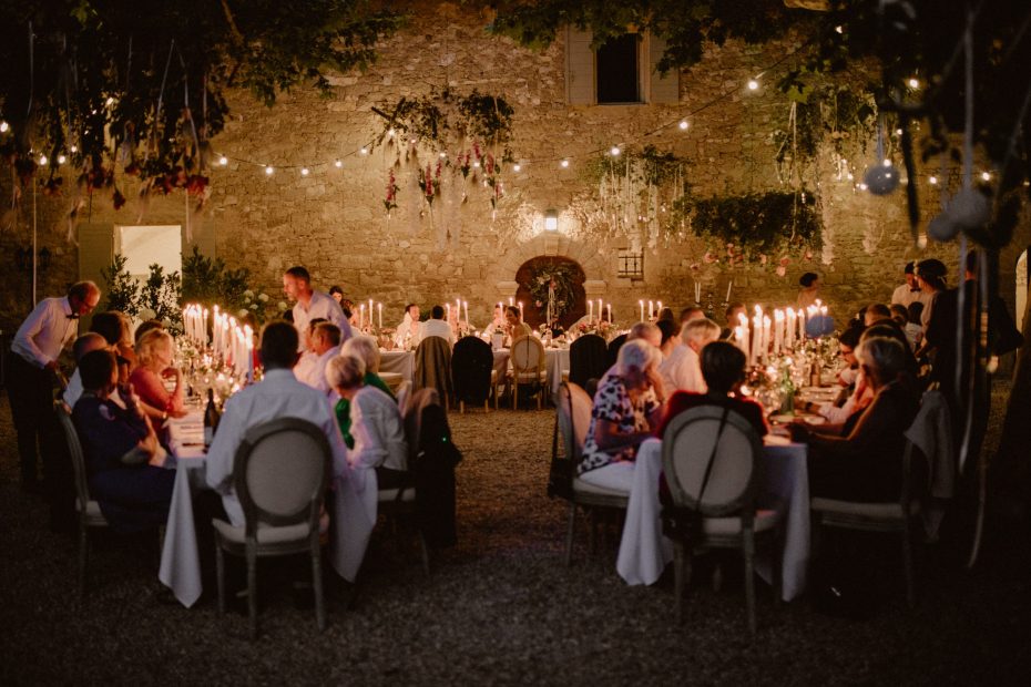 wedding guests dining under fairy light draped courtyard at le Petit Roulet wedding venue in luberon in france