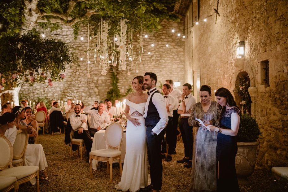 bride and groom stood amongst guests dining outside at le Petit Roulet wedding venue in luberon in france