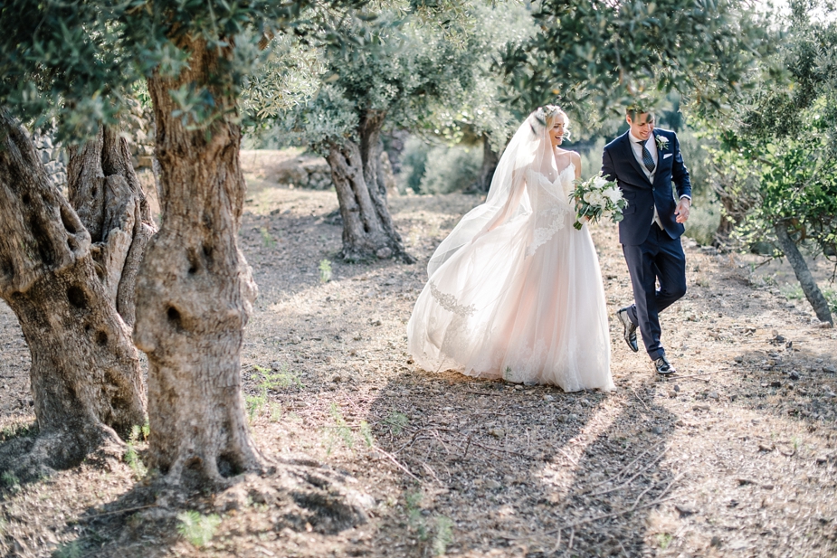 bride and groom walking through th olive groves at luxury wedding venue ca's xorc in mallorca