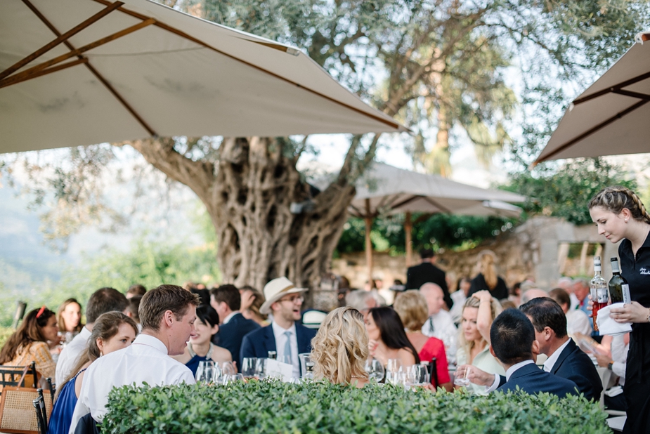 wedding guests dining al fresco under umbrellas at luxury wedding venue ca's xorc in mallorca