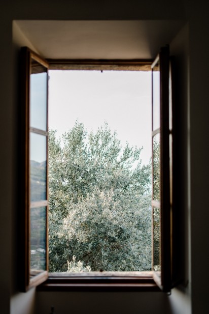 view out the timber framed bedroom window overlooking the surrounding olive groves at luxury wedding venue ca's xorc in mallorca