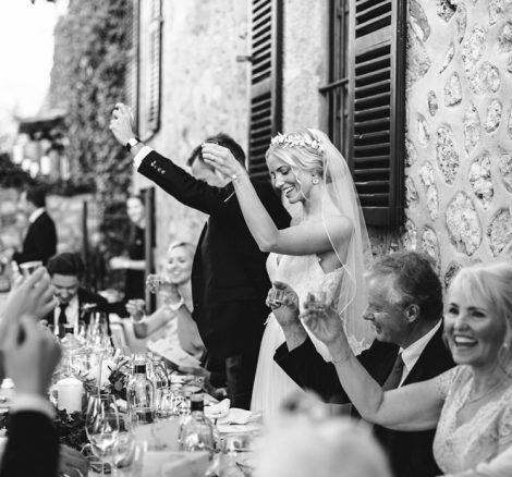 bride and groom standing to cheers whilst dining al fresco at luxury wedding venue ca's xorc in mallorca
