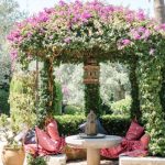 pink flowers cascade over the stone seating area outside luxury wedding venue ca's xorc in mallorca