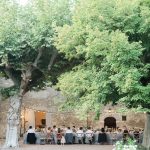 wedding guests dining al fresco in the courtyard at le Petit Roulet wedding venue in luberon in france