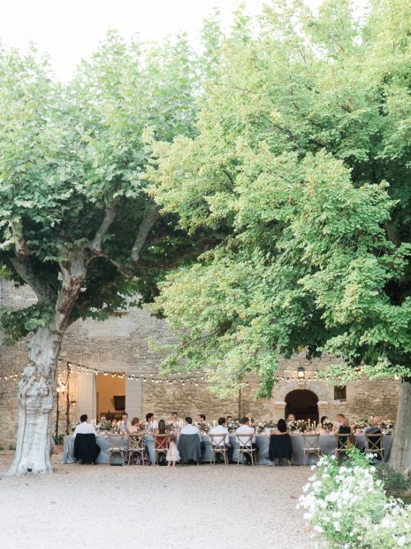 wedding guests dining al fresco in the courtyard at le Petit Roulet wedding venue in luberon in france