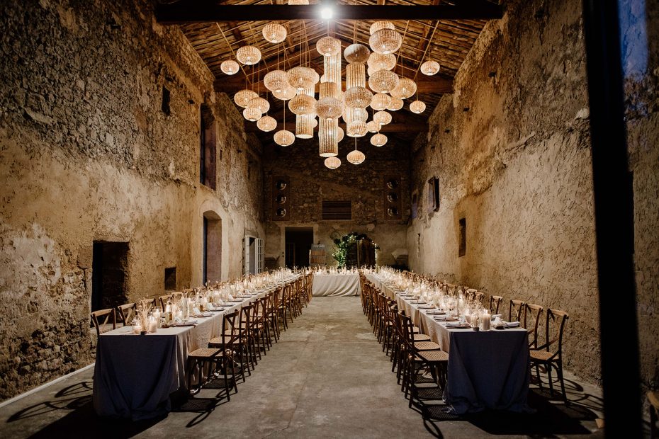 long rectangular tables in gran barn with high ceilings at le Petit Roulet wedding venue in luberon in france