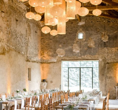 long rectangular wedding tables in old barn with grey linen table runners at wedding venue le Petit Roulet in Luberon france