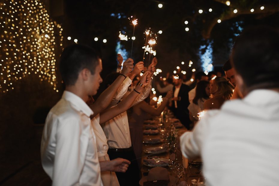 wedding guests with sparklers dining al fresco at le Petit Roulet wedding venue in south of france
