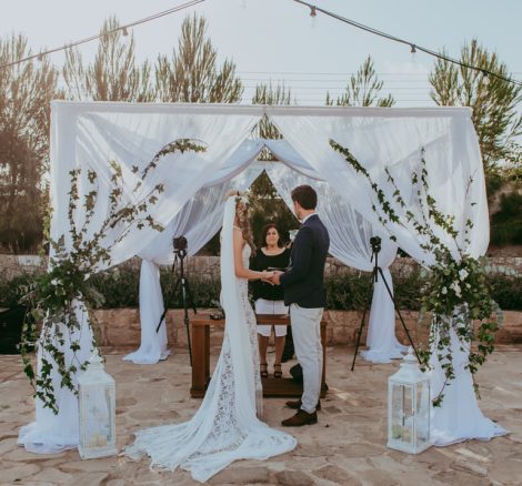draped fabric gazebo where bride and groom stand beneath exchanging vows at wedding venue in Cyprus liopetro