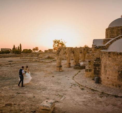 bride and groom walking through archeological site at wedding venue in Cyprus liopetro