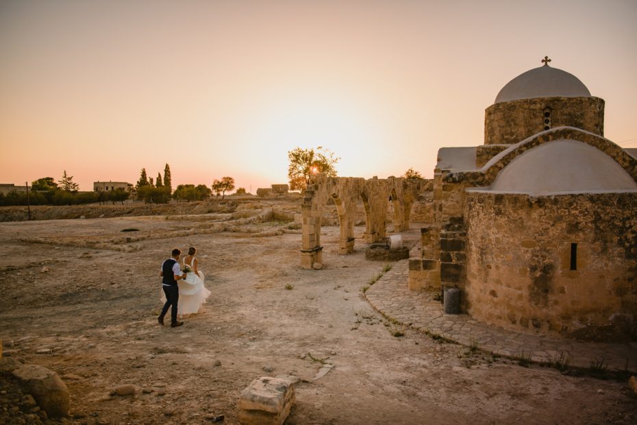 bride and groom walking through archeological site at wedding venue in Cyprus liopetro