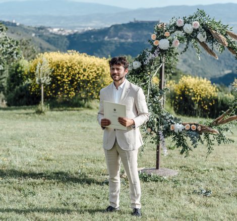 groom waiting for the bride outside on the grounds at wedding venue in italy castello di petrata
