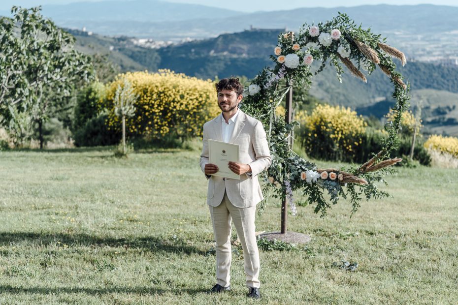 groom waiting for the bride outside on the grounds at wedding venue in italy castello di petrata