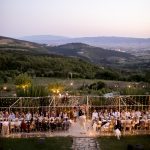 rectangular chic wedding tables with draped festoon lighting overhead at wedding venue in italy castello di petrata