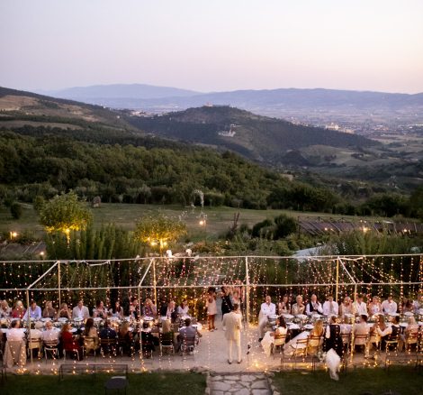 rectangular chic wedding tables with draped festoon lighting overhead at wedding venue in italy castello di petrata