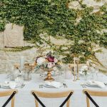 close up of a table for 6 with wooden chairs and neutral chic wedding decor at wedding venue in italy castello di petrata in umbria