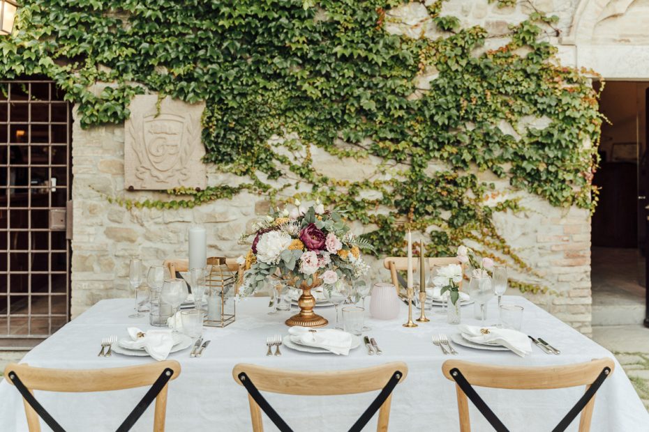 close up of a table for 6 with wooden chairs and neutral chic wedding decor at wedding venue in italy castello di petrata in umbria