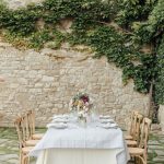 wedding table with wooden chairs and neutral decor at wedding venue in italy castello di petrata