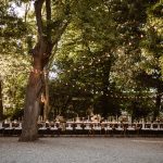 long wedding tables through forest at wedding venue in Tuscany Italy Borgo Stomennano