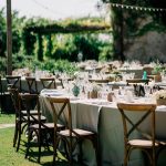 wedding reception wooden chairs and linen on tables oustide wedding venue in italy castello di petrata