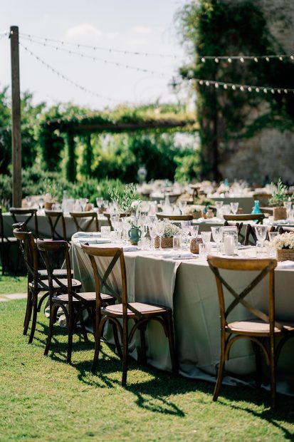 wedding reception wooden chairs and linen on tables oustide wedding venue in italy castello di petrata