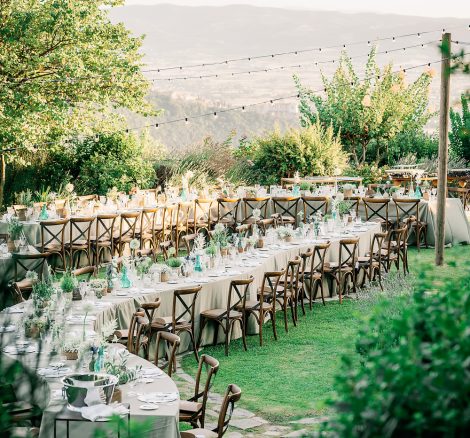 wooden chairs and winding curved tables at wedding venue in italy castello di petrata