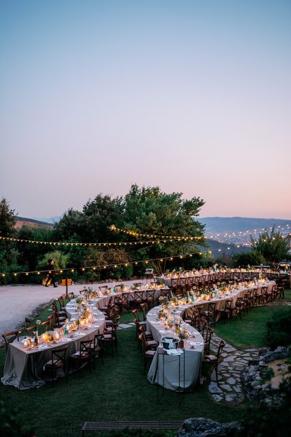 curved wedding tables outside on the grounds at wedding venue in italy castello di petrata in umbria