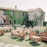 rattan wedding chairs positioned on the lawn oustide wedding venue in italy castello di petrata