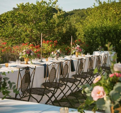 wooden wedding chairs and long linen laid tables outside at wedding venue in italy castello di petrata