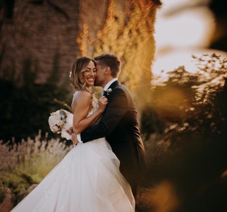 bride and groom kiss outside on the grounds at sundown at wedding venue in italy castello di petrata