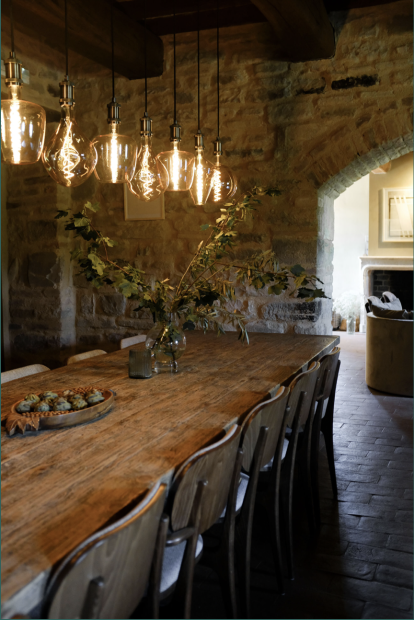 long wooden table with hanging lights at wedding venue Borgo Castello Panicaglia