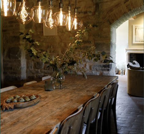 long wooden table with hanging lights at wedding venue Borgo Castello Panicaglia