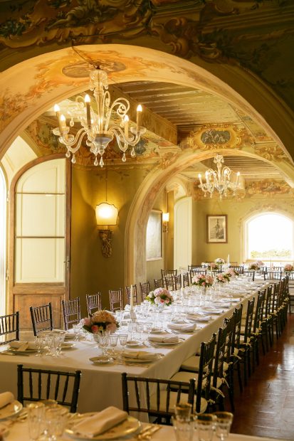 long tables inside under arched ceiling at wedding venue in Tuscany Italy Borgo Stomennano