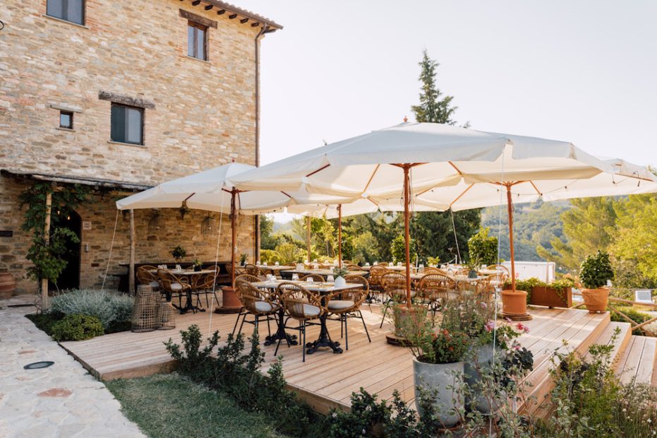 seated dining area with white umbrellas at wedding venue Borgo Castello Panicaglia