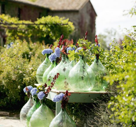 collection of large green glass florists bottles as wedding decor at wedding venue in italy castello di petrata