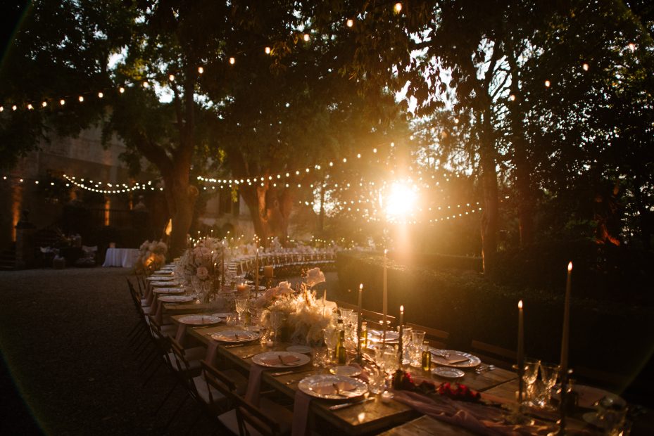 sundown over wedding tables in forested area at wedding venue in Tuscany Italy Borgo Stomennano