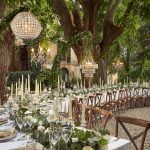 chandeliers hung from trees over wedding tables at wedding venue in Tuscany Italy Borgo Stomennano