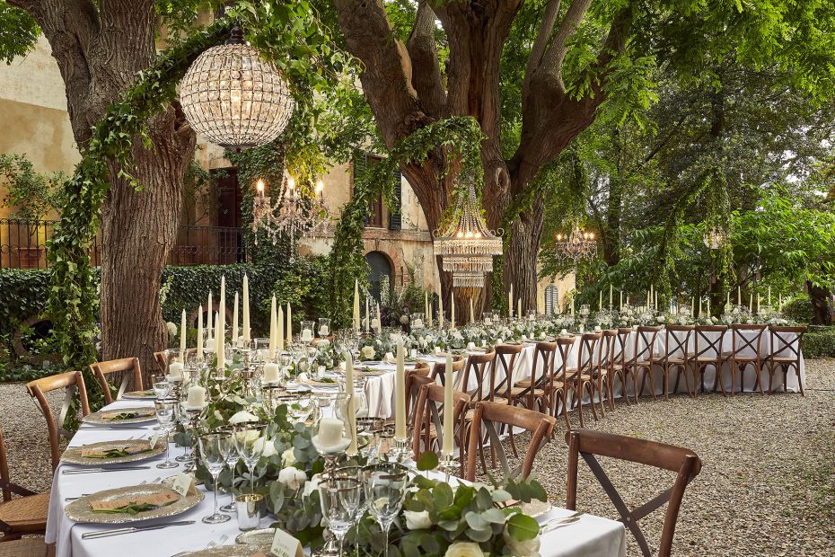 chandeliers hung from trees over wedding tables at wedding venue in Tuscany Italy Borgo Stomennano