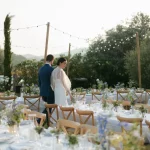 Image of married couple walking around tables looking at decorations at wedding venue Clos du Tuilier